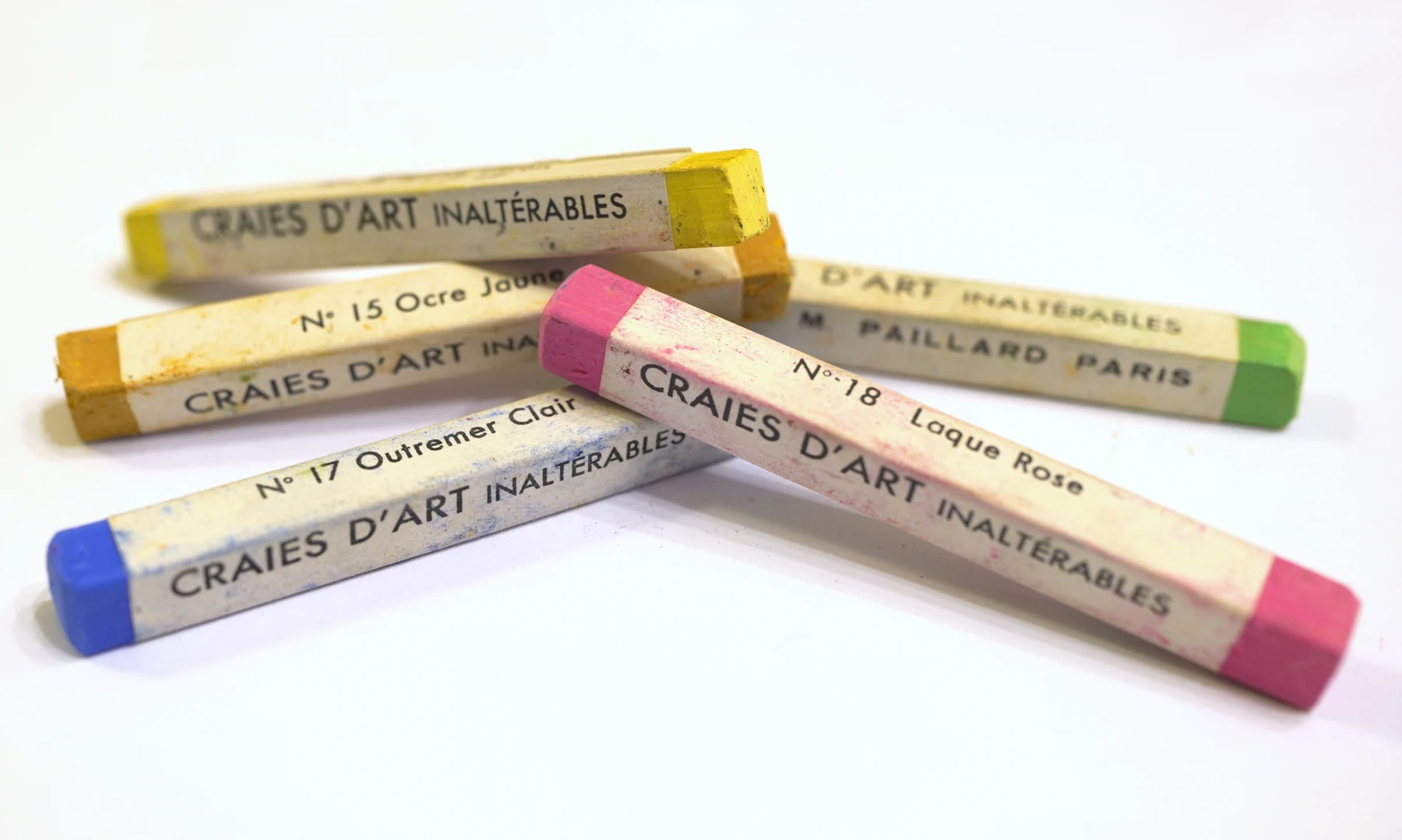 A close-up of brightly coloured artists’ pastel sticks arranged together.