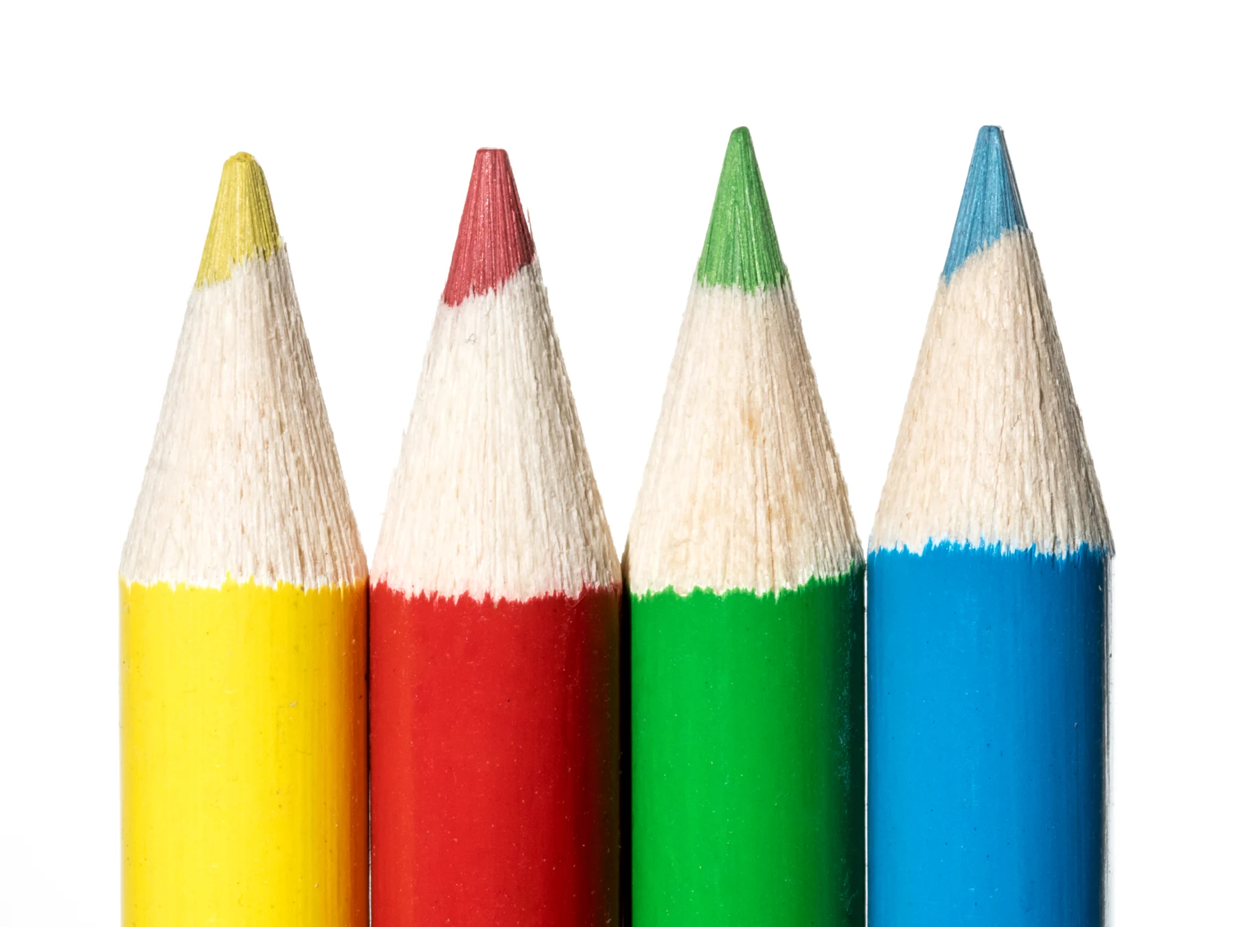 Four sharpened coloured pencils in yellow, red, green and blue against a white background.
